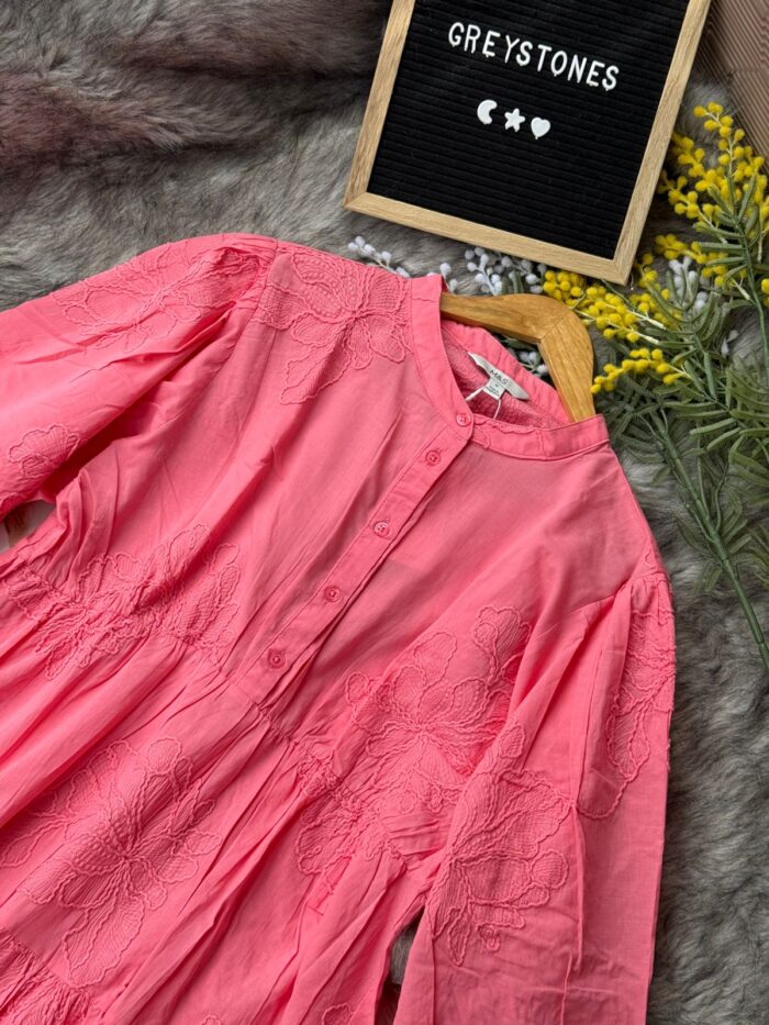 Coral pink embroidered cotton tunic dress with long sleeves, button-down front, and tiered flowy design,