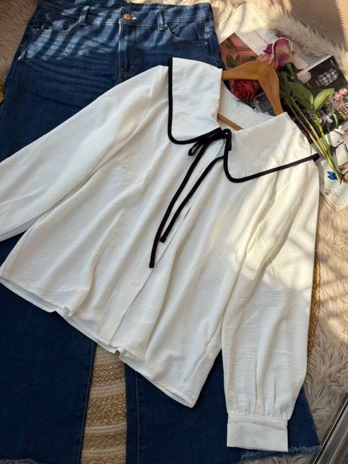 White blouse with wide black-trim collar and ribbon tie